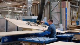 Man loading panel on CNC machine