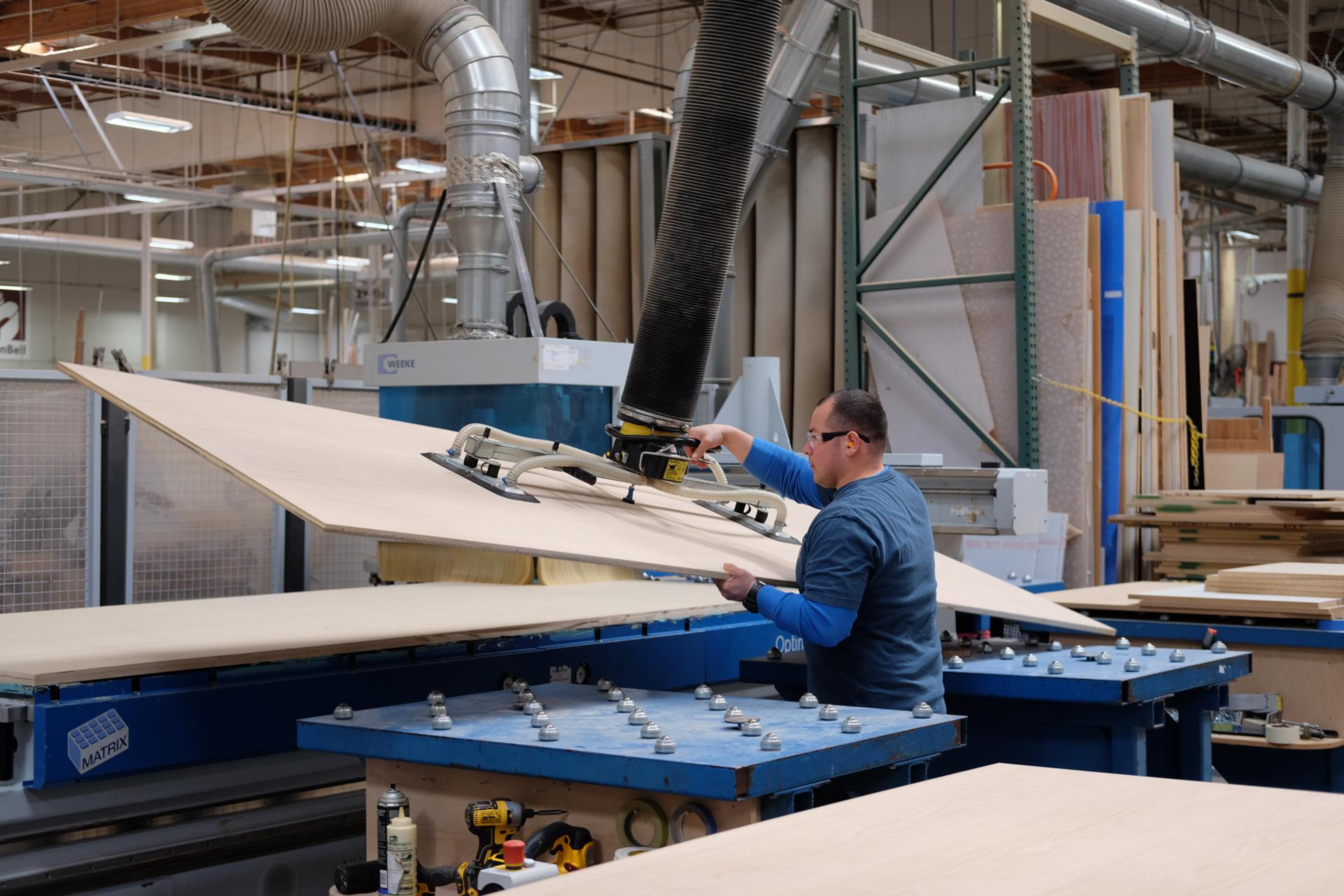 Man loading panel on CNC machine